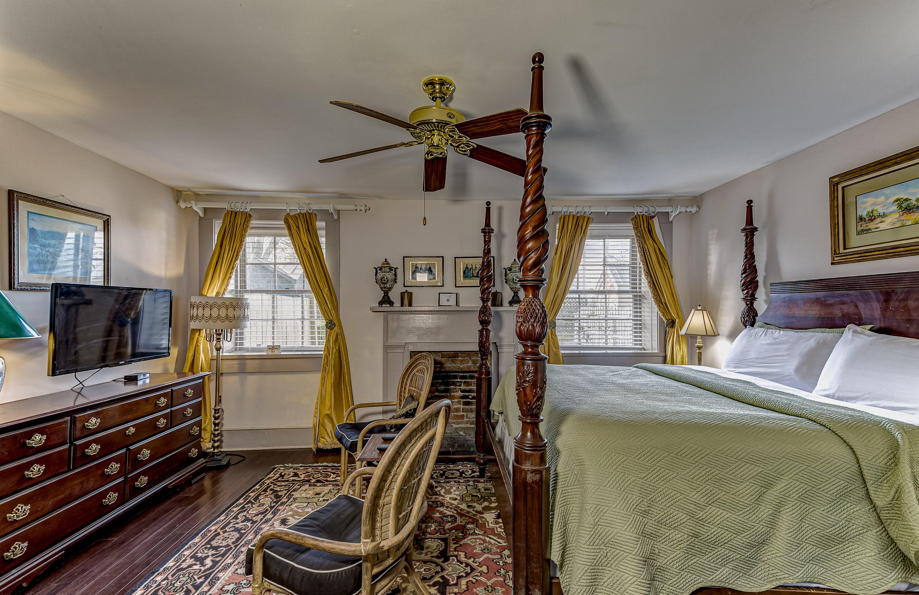 king bed, ceiling fan, end tables on each side of bed with lamps