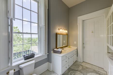 large window in bathroom, double vanity with mirror and group of lights