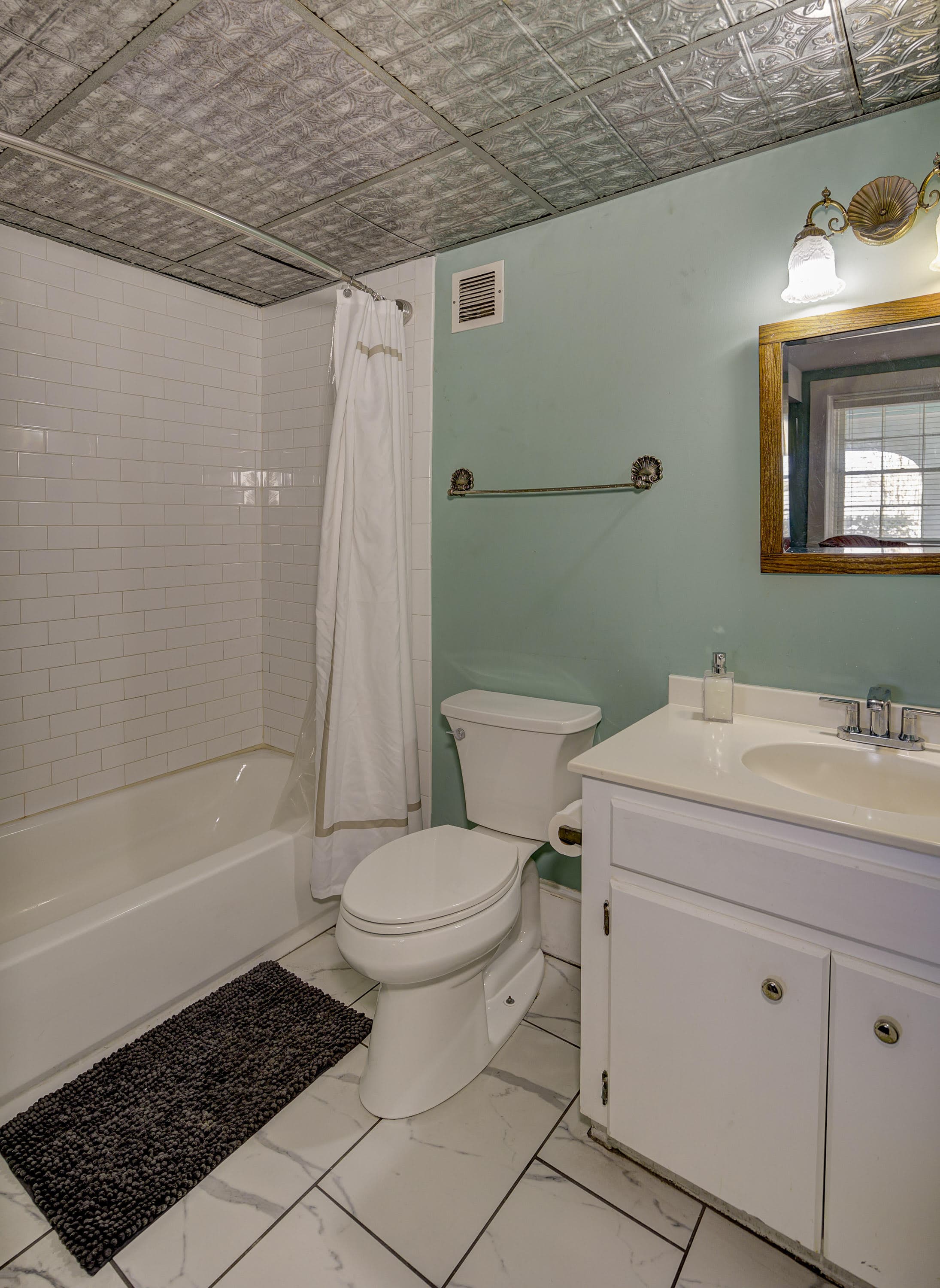 New bathtub with white bath surround, tin ceiling for character