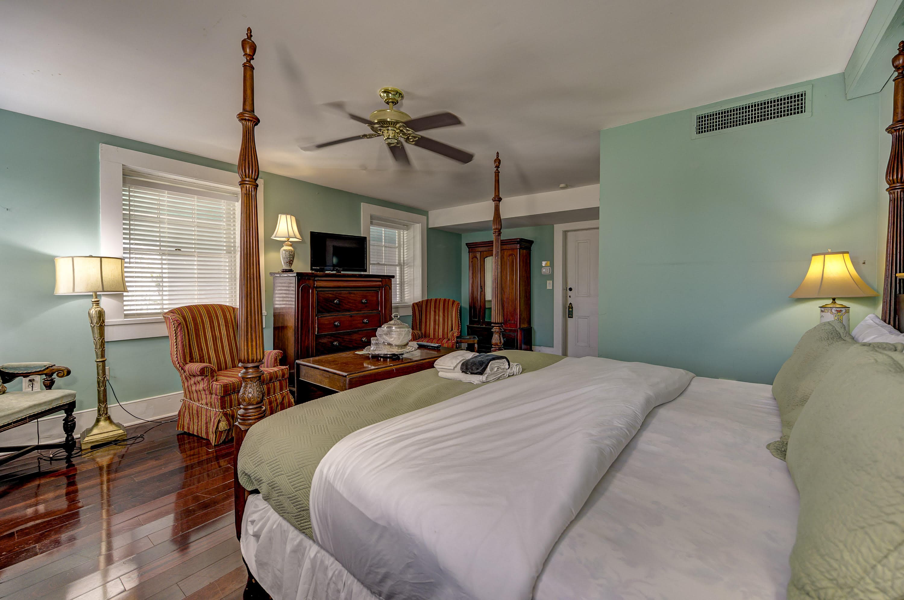 king bed, teal bedroom, ceiling fan, hardwood floors