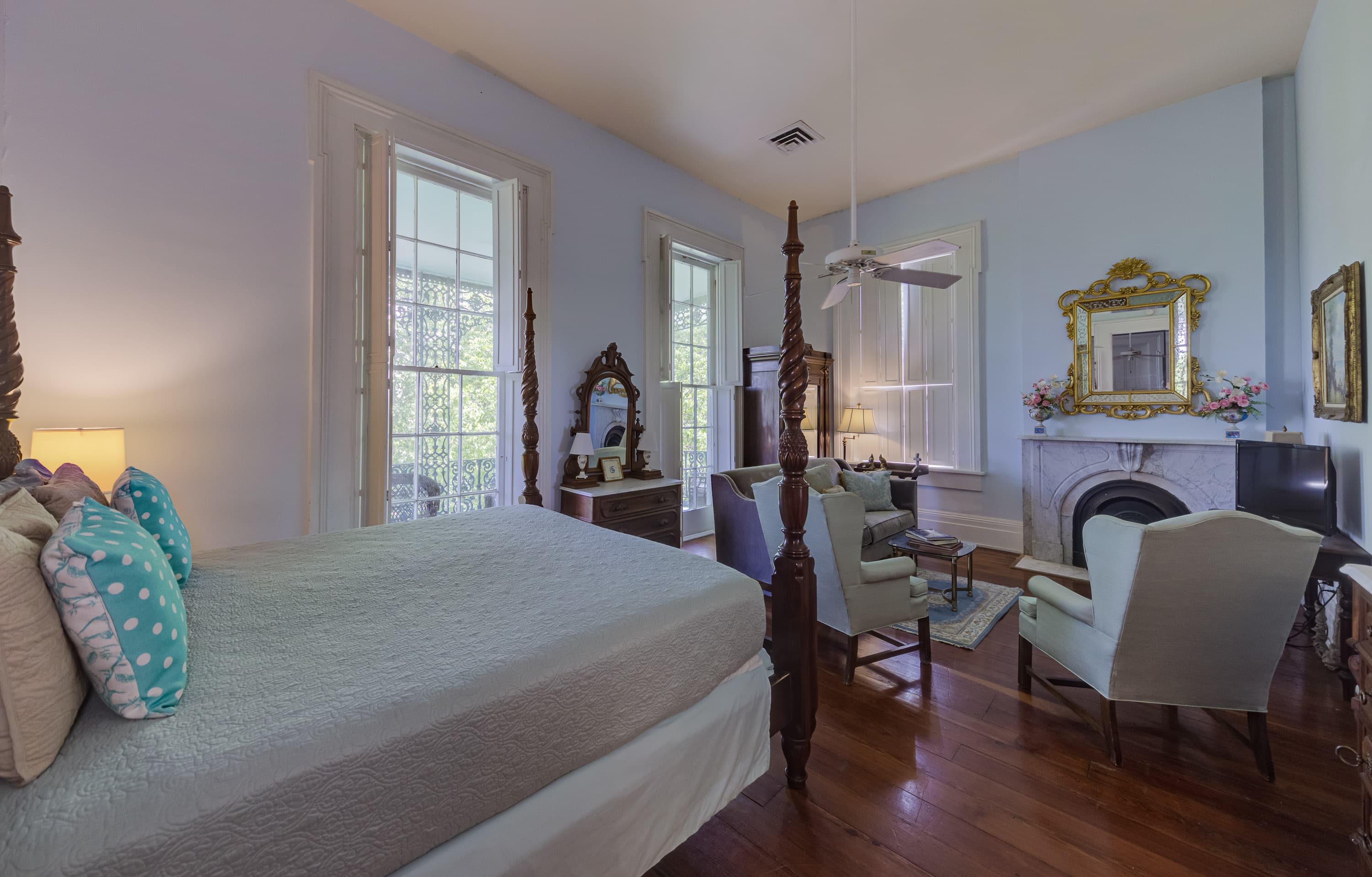 Four poster bed, tall windows, Victorian dresser, two wing chairs