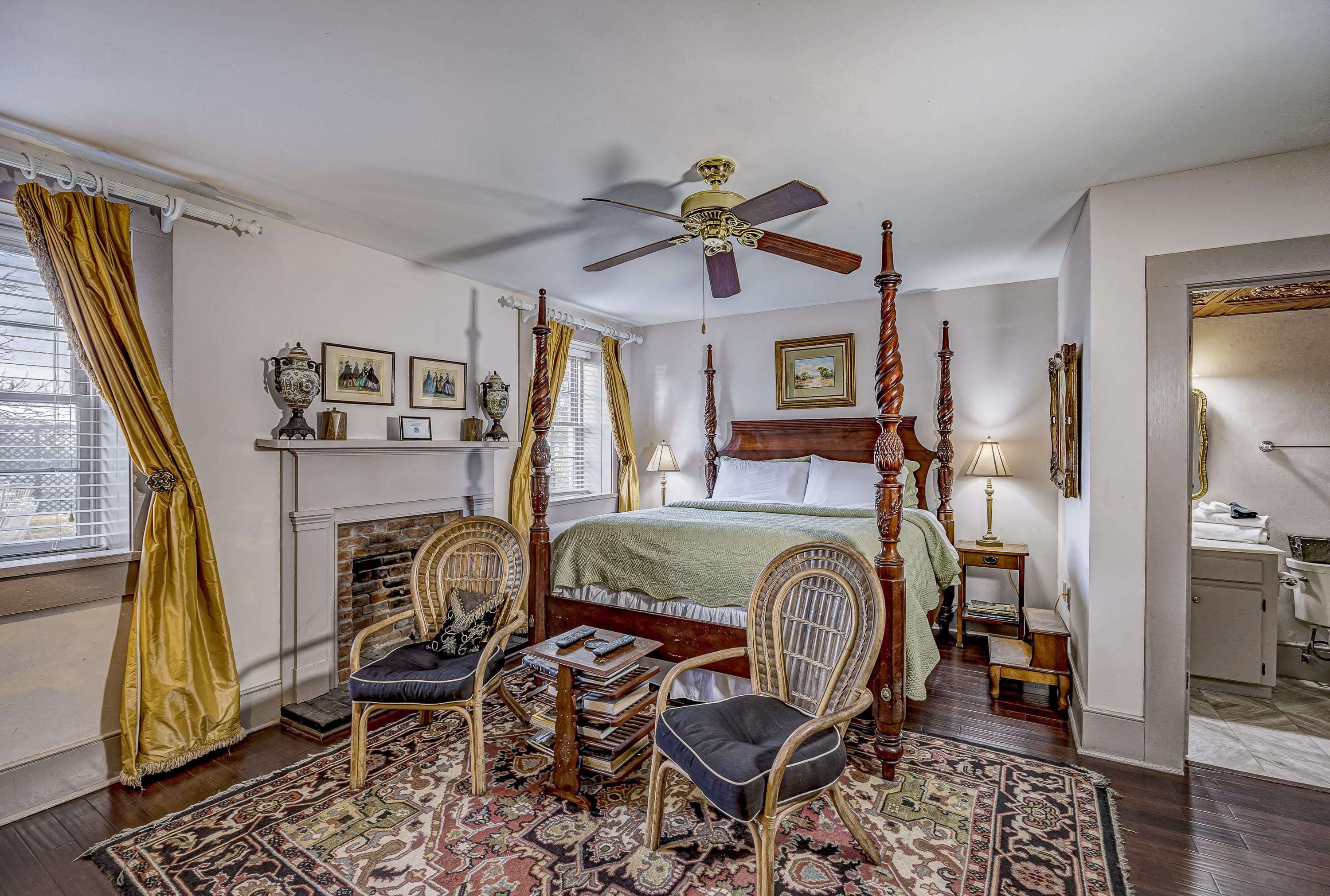 Cozy bedroom featuring a four-poster bed, comfortable seating area, and elegant decor.