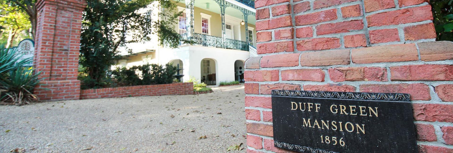 Brick entrance with a plaque reading "Duff Green Mansion 1856" in front of a historic house.