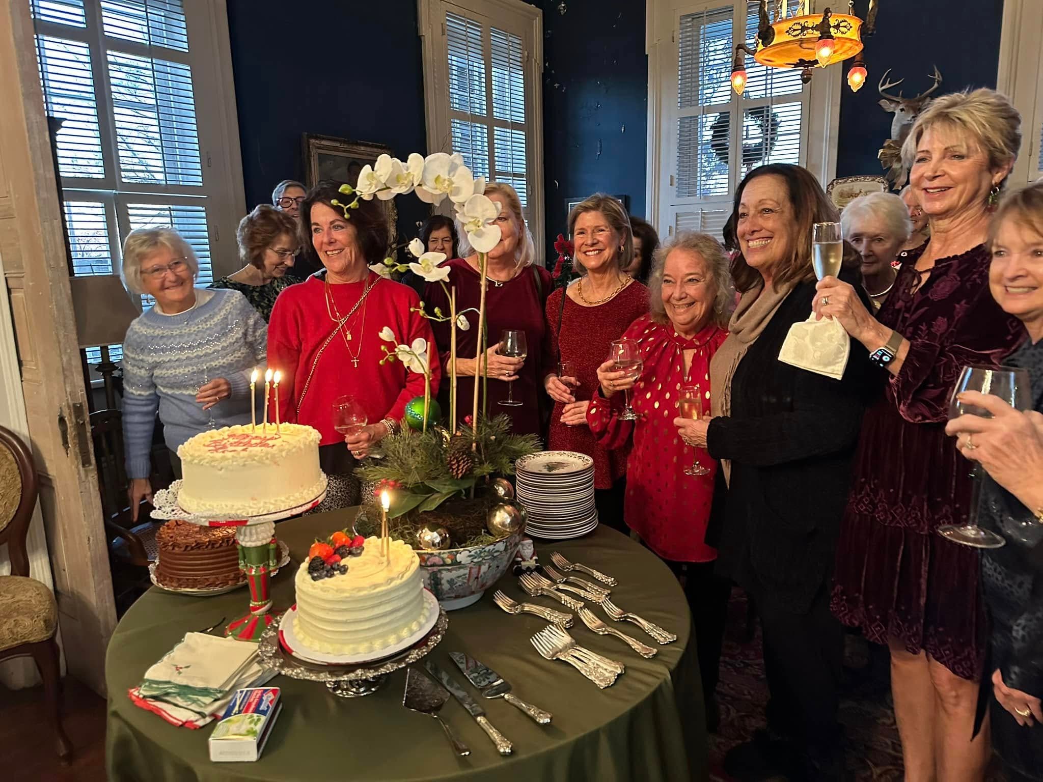 A group of women celebrating with drinks and cakes at a festive gathering.