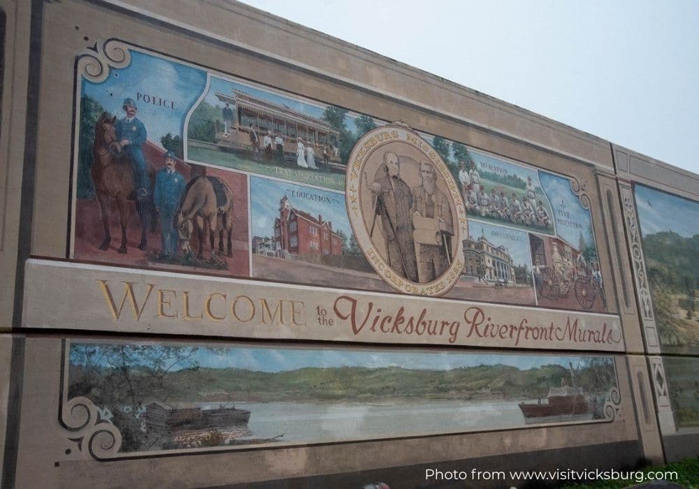 A vibrant mural welcoming visitors to the Vicksburg Riverfront, showcasing local history and scenes.