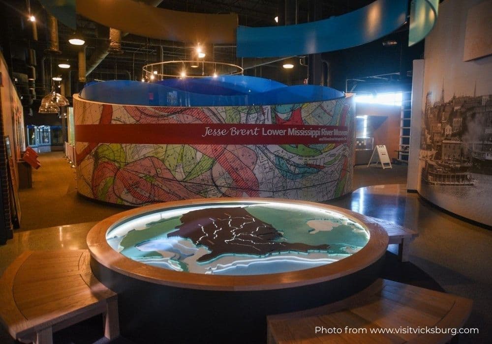 Interior view of the Jesse Brent Lower Mississippi River Museum, featuring a circular map display and colorful wall graphics.